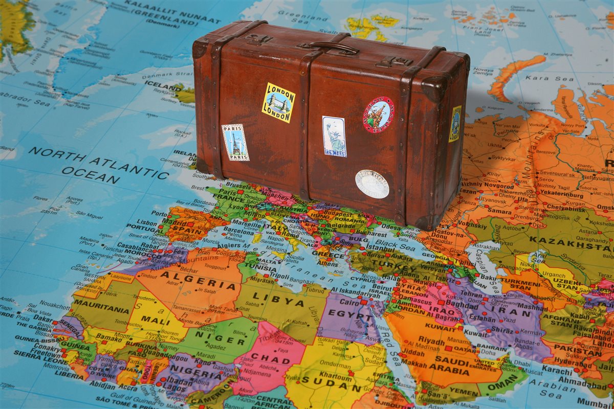 Suitcase and world map &mdash; planning a global trip